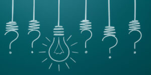 Imagem de um quadro negro com várias interrogações no lugar de lâmpadas, e uma lâmpada conectada no meio