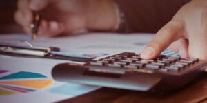 Foto de uma pessoa usando uma calculadora