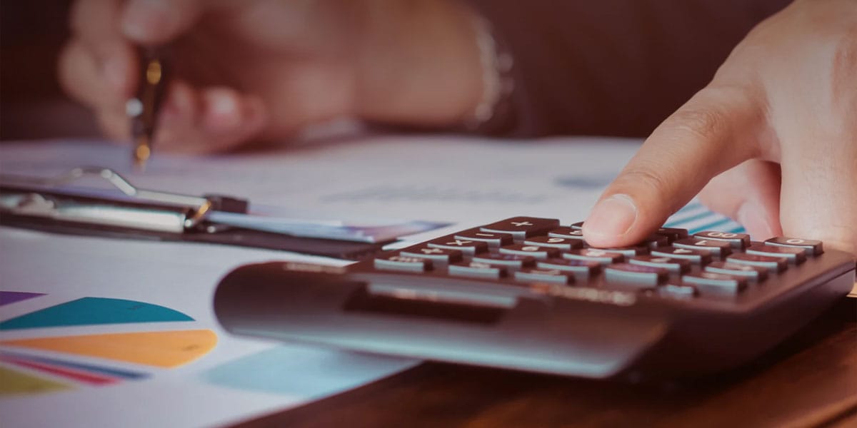 Foto de uma pessoa usando uma calculadora