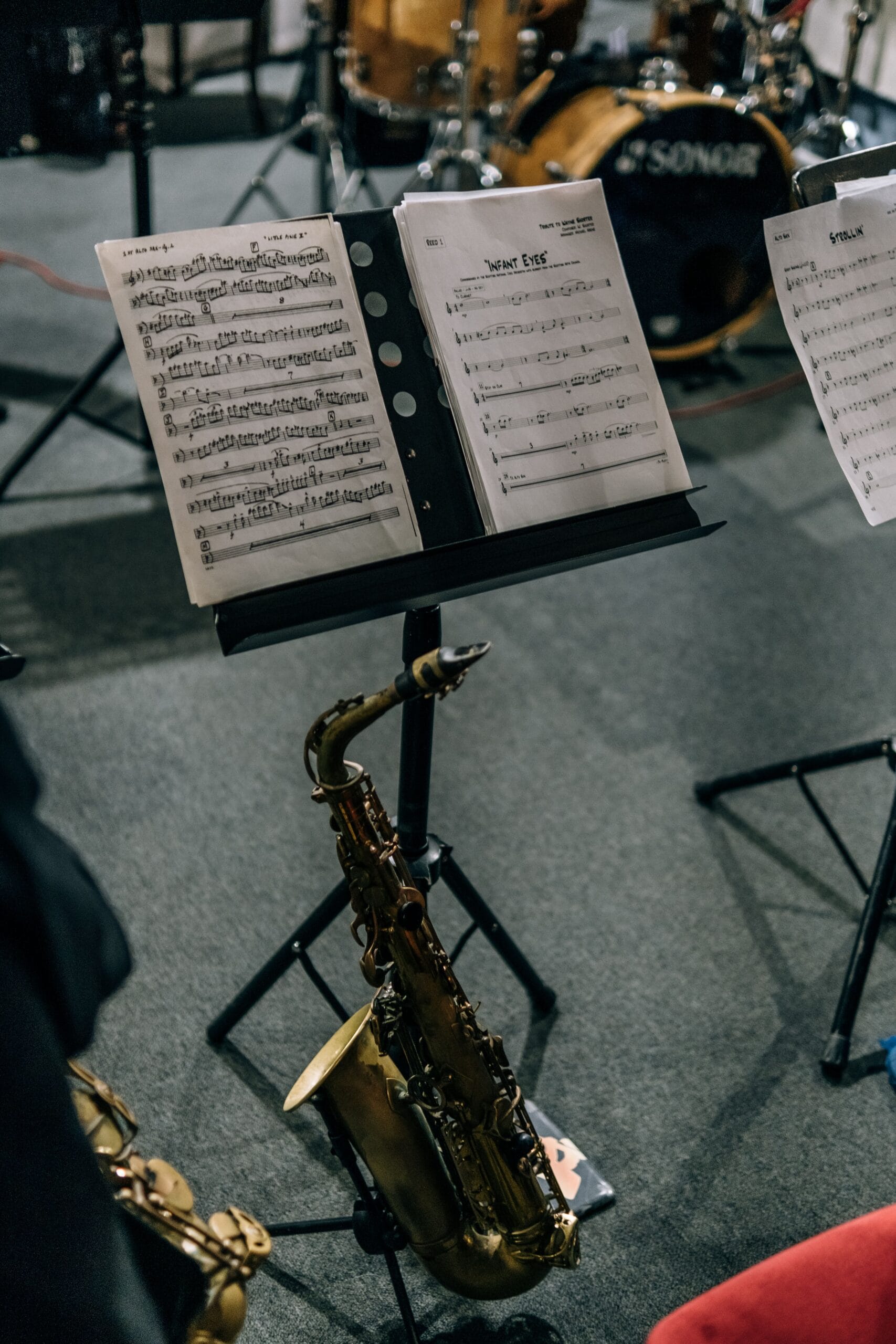 Close-up of a saxophone and sheet music stand, perfect for jazz lovers and musicians.