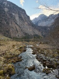 Serene stream flowing through Bavarian mountains, capturing winter beauty and natural tranquility.