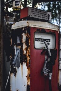 Retro fuel pump with rusty metal and vintage design, featuring a nozzle and liter meter.