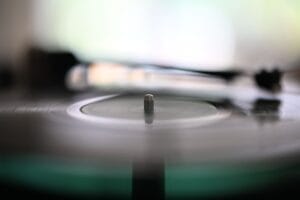 Blurry spinning vinyl record with needle on turntable, capturing the essence of analog music.