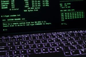 A classic MS-DOS terminal screen displayed on a laptop keyboard with vivid illumination.