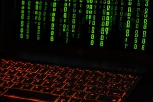 Código binario verde sobre el teclado de un portátil, representando datos internos de Python.