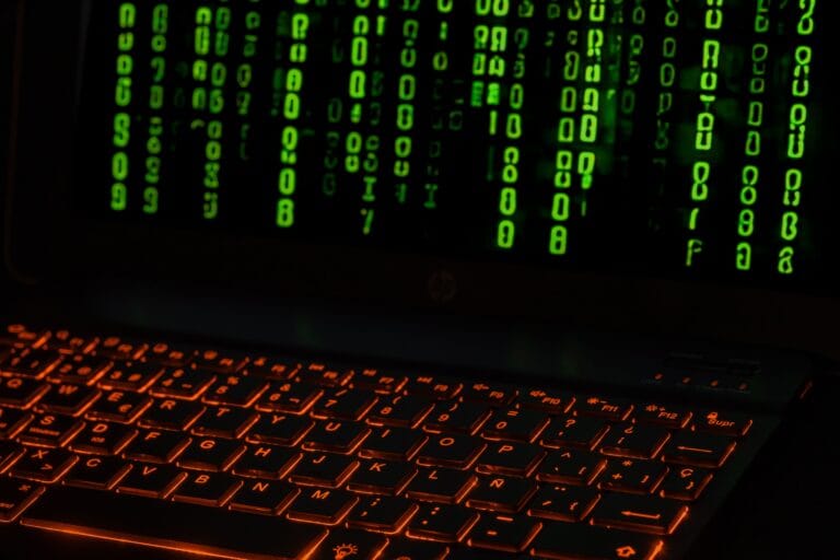 Código binario verde sobre el teclado de un portátil, representando datos internos de Python.