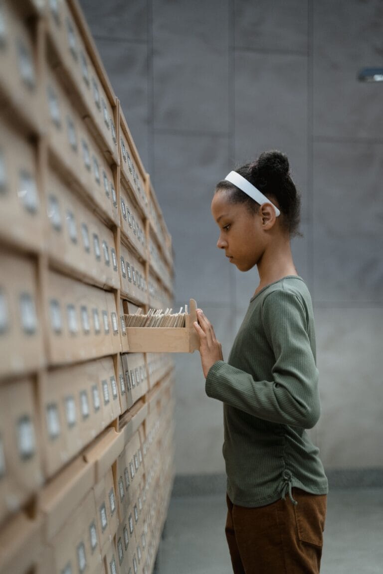 A young girl exploring a library's card catalog, symbolizes research and curiosity.